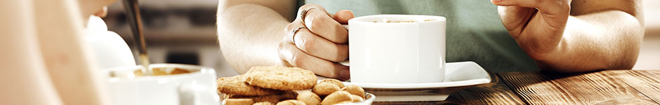 Person sitting at a table with a cup of coffee